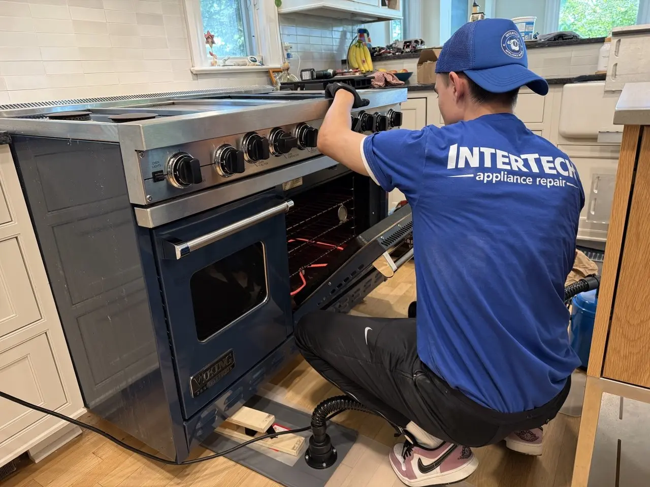 InterTech technician inspecting a Sub-Zero refrigerator during an appliance repair visit